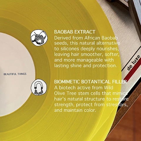 Image 1 - A yellow vinyl record partially covers a wooden surface, displaying two illustrated circular icons with text that reads BAOBAB EXTRACT Derived from African Baobab seeds, this natural alternative to silicones deeply nourishes, leaving hair smoother, softer, and more manageable with lasting shine and protection. BIOMIMETIC BOTANICAL FILLER A biotech active from Wild Olive Tree stem cells that mimics hair’s natural structure to restore strength, protect from stressors, and maintain color. The record label itself reads BEAUTIFUL THINGS and de luxe is visible on the wooden surface. Image 2 - A close-up of a red vinyl record playing on a turntable displays two white text boxes describing ingredients: CHELATING COMPLEX With upcycled citrus peel extract, this multi-active complex removes metal and mineral buildup from water and pollution, delivering a sustainable, effective hair detox and VEGAN COLLAGEN A biotech-powered peptide that mimics the structure of collagen to strengthen hair from within, boosting shine, smoothness, and elasticity, with the record label also showing the text BEAUTIFUL THINGS. Image 3 - A close-up of a blue marbled record with a white label, part of a record player visible on the right, features text that reads: WHY IS IT IMPORTANT TO RESTORE HAIR LIPIDS? Lipids are the hairs natural protective barrier. They can be depleted after extensive heat exposure, coloring, or bleaching. Beautiful Things leave-in hair mask restores this barrier, increasing its strength and performance, by up to 200%. On the white label, the text reads: BEAUTIFUL THINGS. Image 4 - A person with deep red curly hair and a magenta shirt looks down, next to text on the left that reads Lasting color results for up to 7 weeks**, Immediately shinier and 1.5x softer hair***, and Protects against heat damage up to 450°F*, with additional disclaimer text at the bottom right that reads *Independent laboratory, instrumental test on treated hair locks vs untreated hair locks. **Internal laboratory, instrument tests on hair locks colored with semi-permanent dye, treated vs untreated hair locks. Results may vary depending on hair quality. ***Internal laboratory, instrumental test on treated hair locks vs untreated hair locks. Image 5 - A person with sleek, short, light blonde hair is shown in profile against a blue-grey background, with text that reads: Restores hair lipids by up to 200%* Repairs hair structure by up to 91%* *Independent laboratory, instrumental test on treated hair locks vs untreated hair locks. **Internal laboratory, instrument tests on hair locks colored with semi-permanent dye, treated vs untreated hair locks. Results may vary depending on hair quality. ***Internal laboratory, instrumental test on treated hair locks vs untreated hair locks. Image 6 - A dark brown spray bottle with a white label displaying product details for BEAUTIFUL THINGS RESTORING LEAVE IN MASK is centered on the white label of a yellow vinyl record, with the text BEAUTIFUL THINGS YOUR COLOUR IS OUR CARE prominently displayed above it.